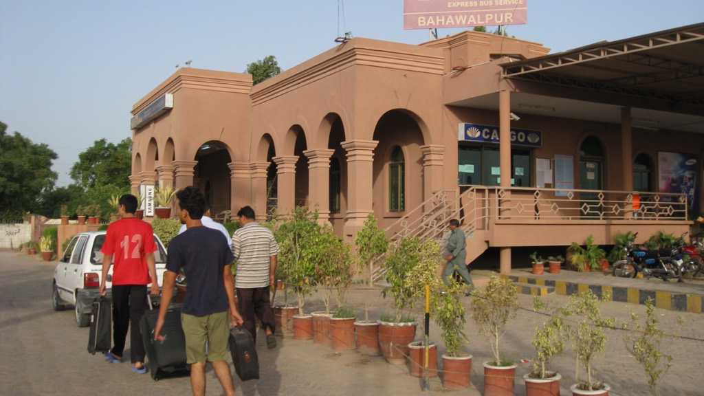 Passengers with luggage outside an intercity coach terminal in Bahawalpur